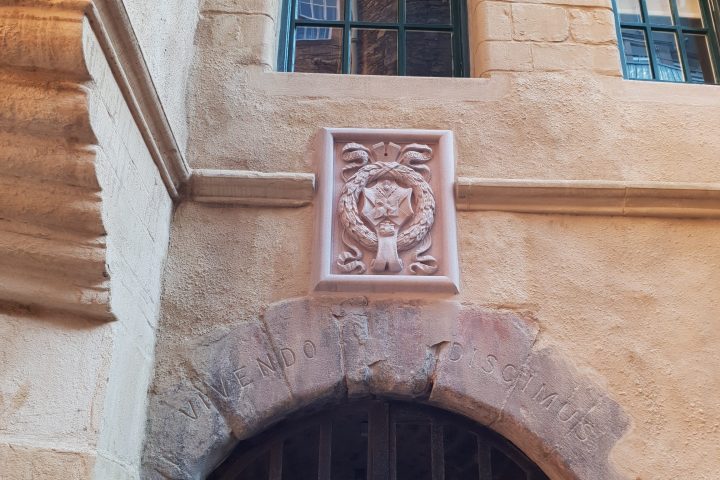 a large stone building with a clock on the front of a window