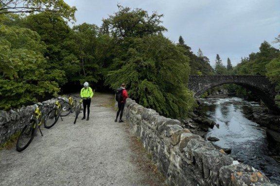 a group of people crossing a bridge over a river