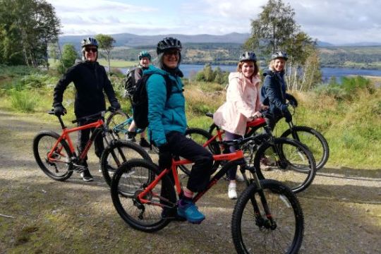 a group of people riding on the back of a bicycle