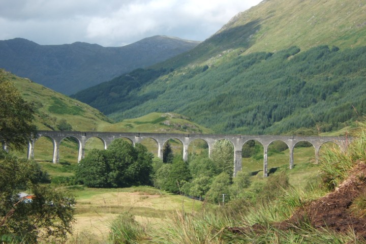 a train crossing a bridge over a hill