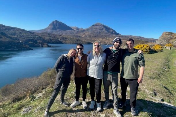 a group of people standing in front of a mountain