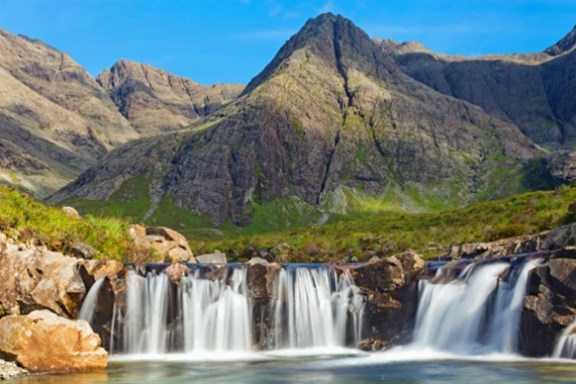 a large waterfall in front of a mountain