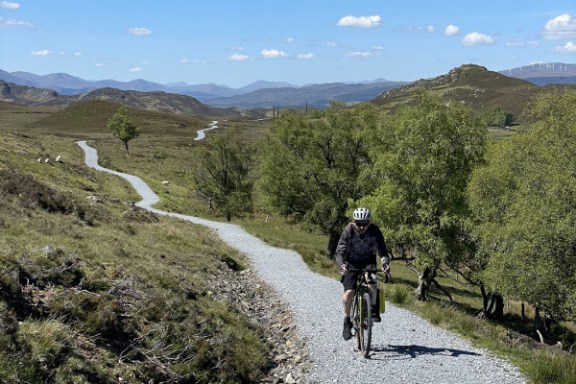 a man riding a bike down a dirt road
