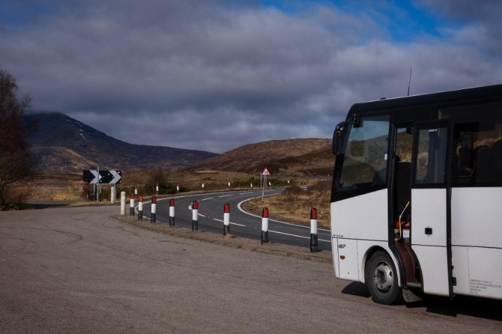 a passenger bus that is parked on the side of a road