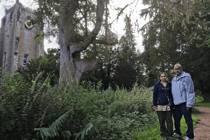 a man standing next to a tree