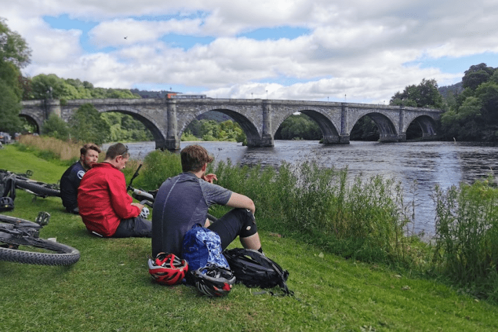 a group of people on a bridge over a river