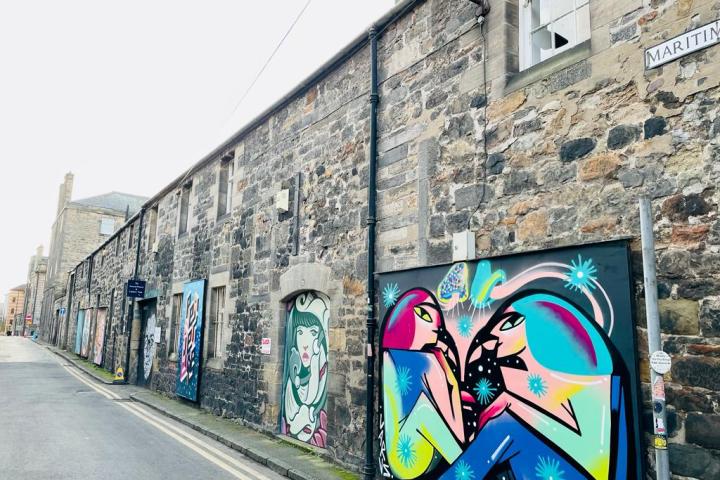 a building with graffiti on the side of a road