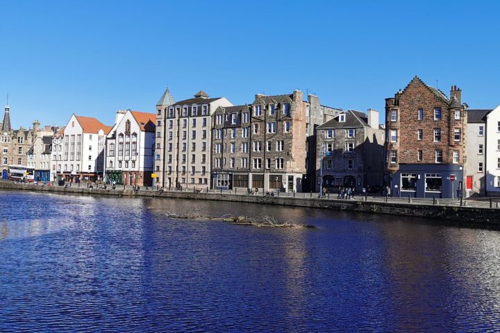 a small boat in a body of water with buildings in the background