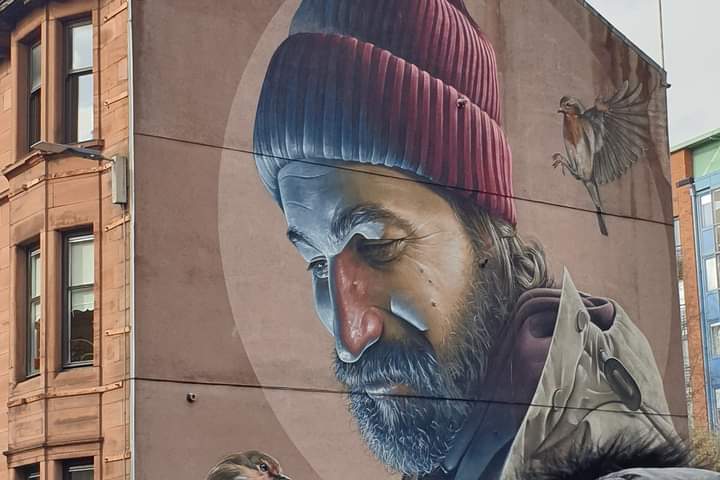 a statue of a person sitting in front of a building