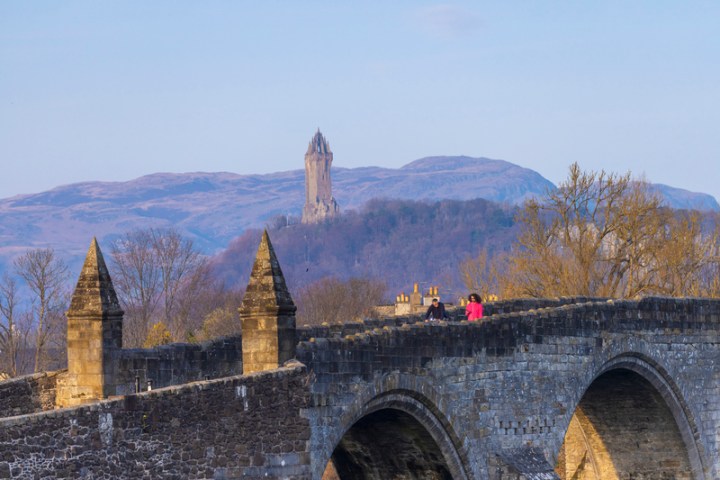 a large stone building with a mountain in the background