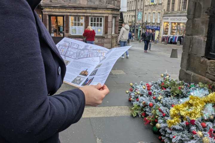 a person standing on a sidewalk in front of a building