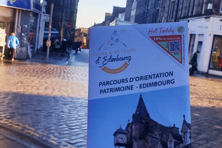 a person holding a sign in front of a building